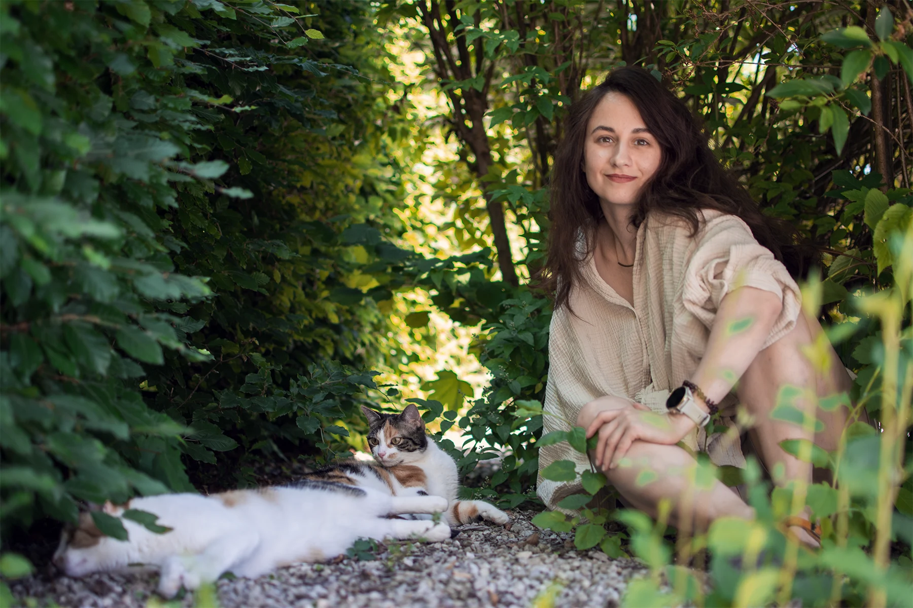 Margareta sitzt mit einer Katze im Garten